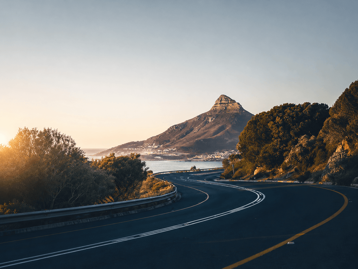 The coastal road curving beneath Lion's Head at sunset